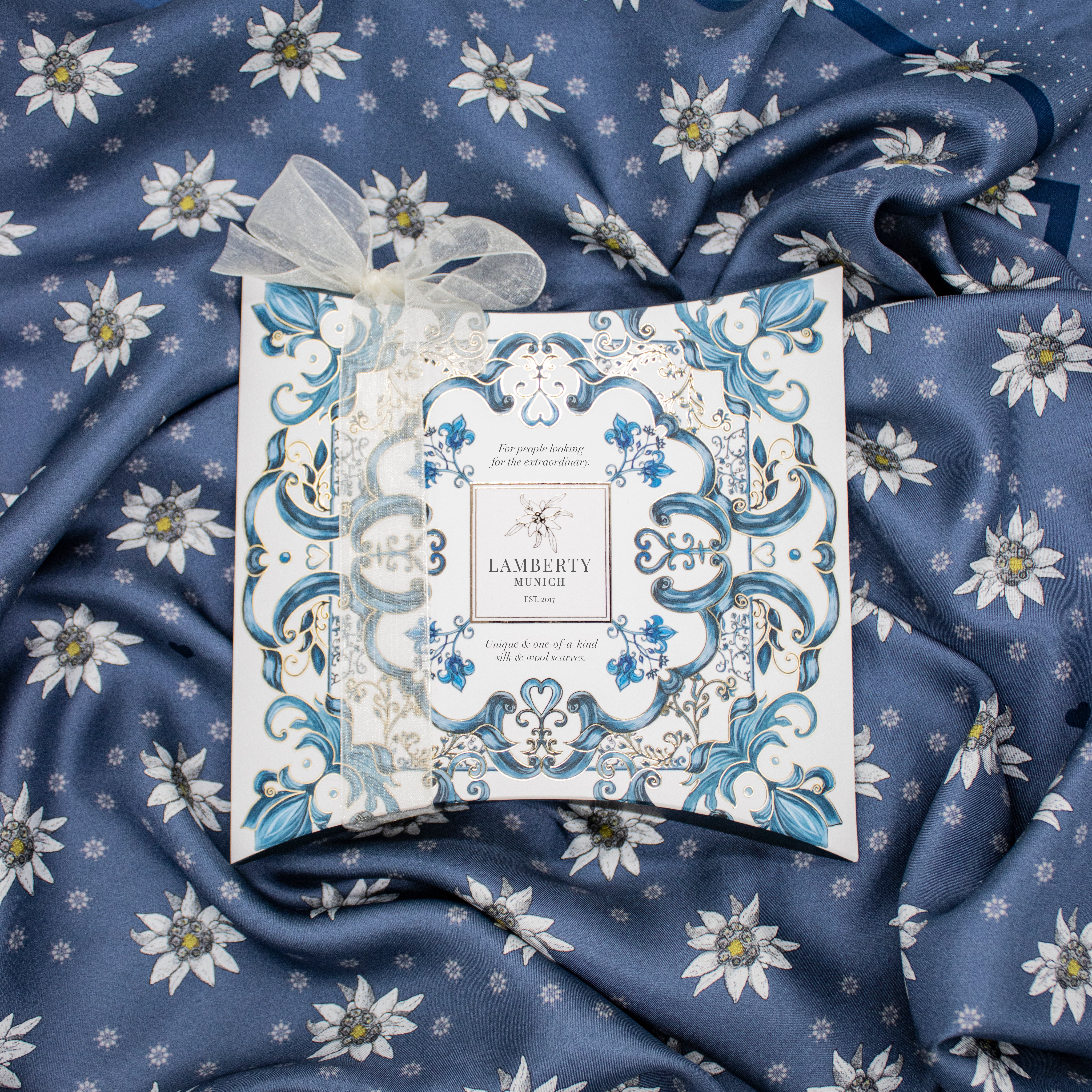 Lamberty Munich gift box with an organza ribbon on a navy silk scarf with white edelweiss flowers